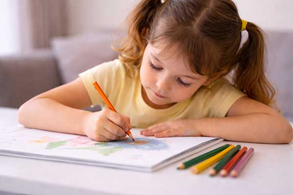 Kind malt konzentriert mit Buntstiften – ruhige Beschäftigung zur Förderung von Konzentration und Entspannung bei Kindern